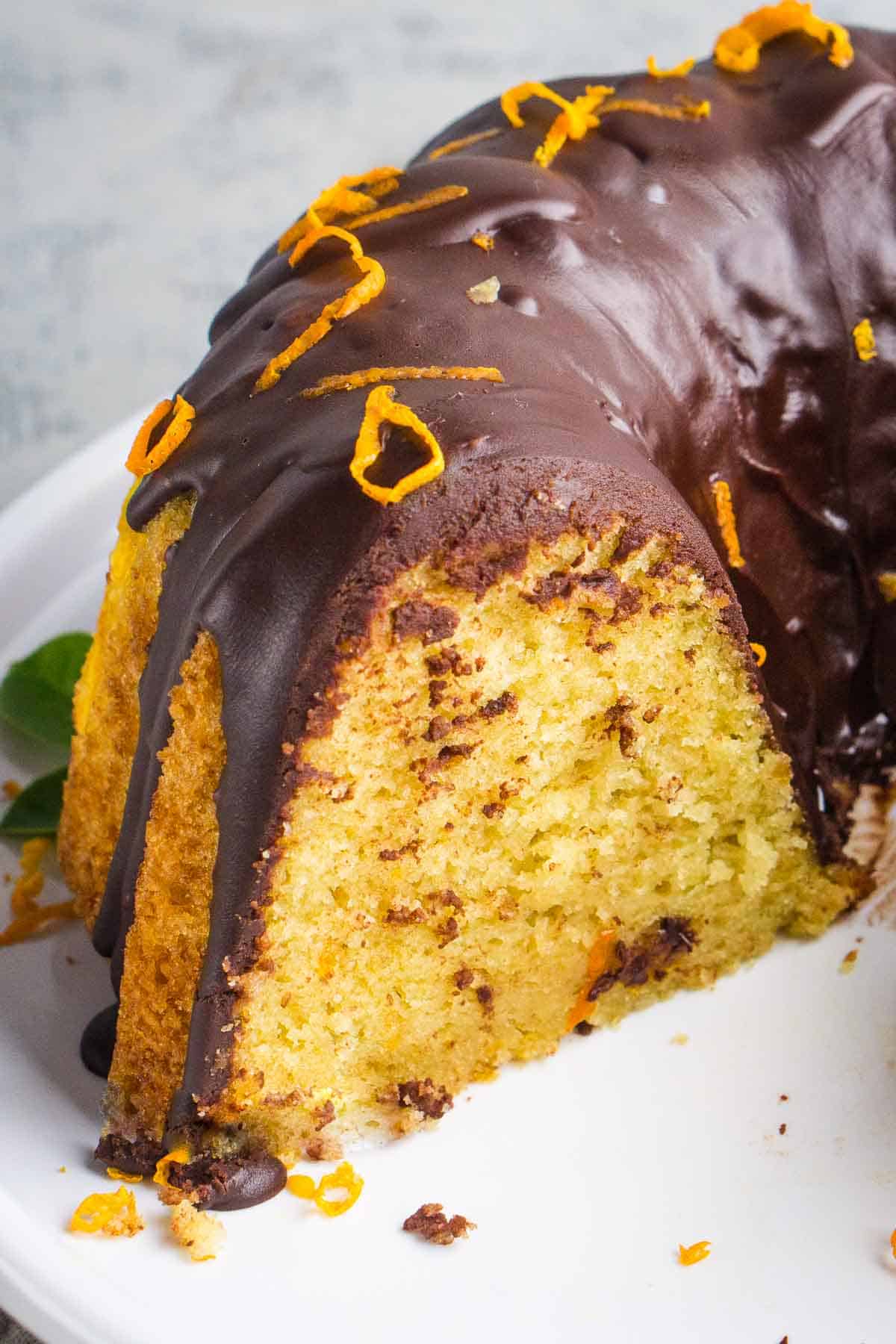 Inside slice of orange olive oil cake with chocolate ganache topping.
