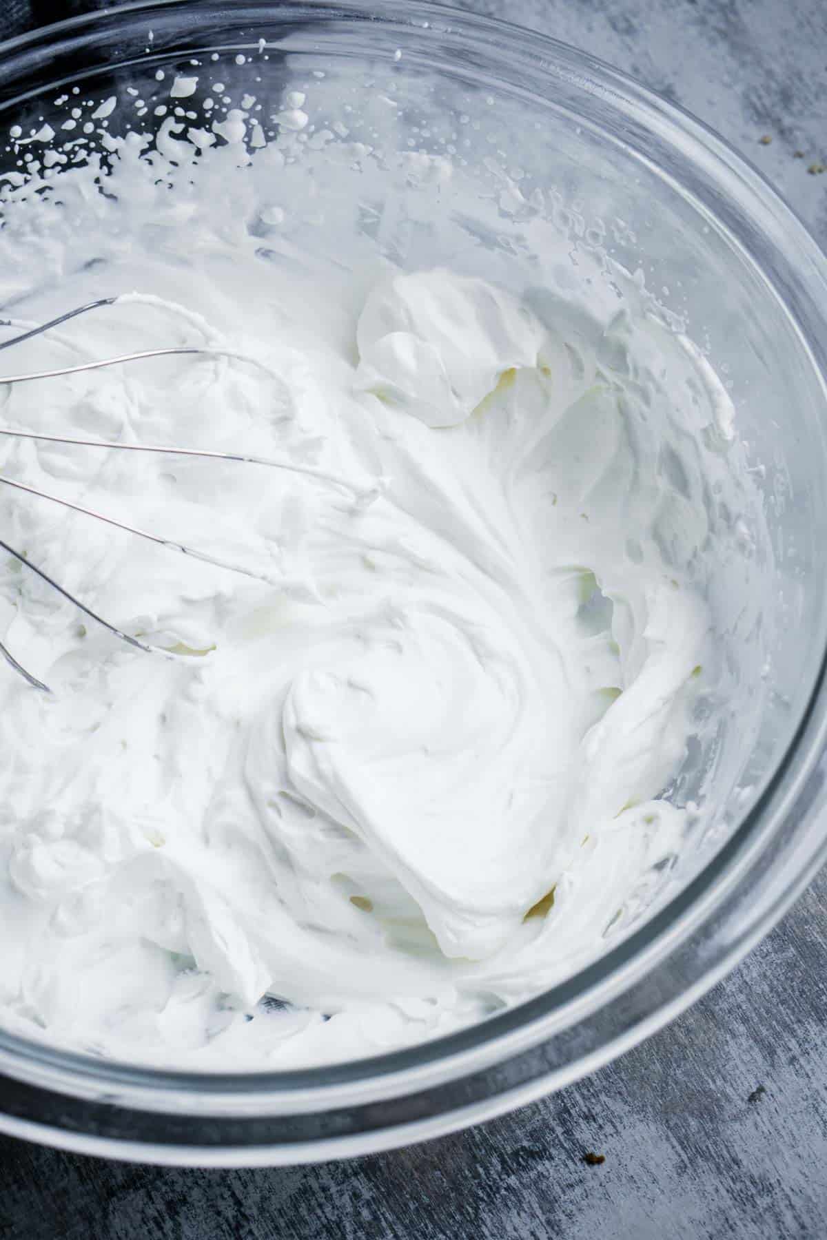 whipped cream in glass mixing bowl