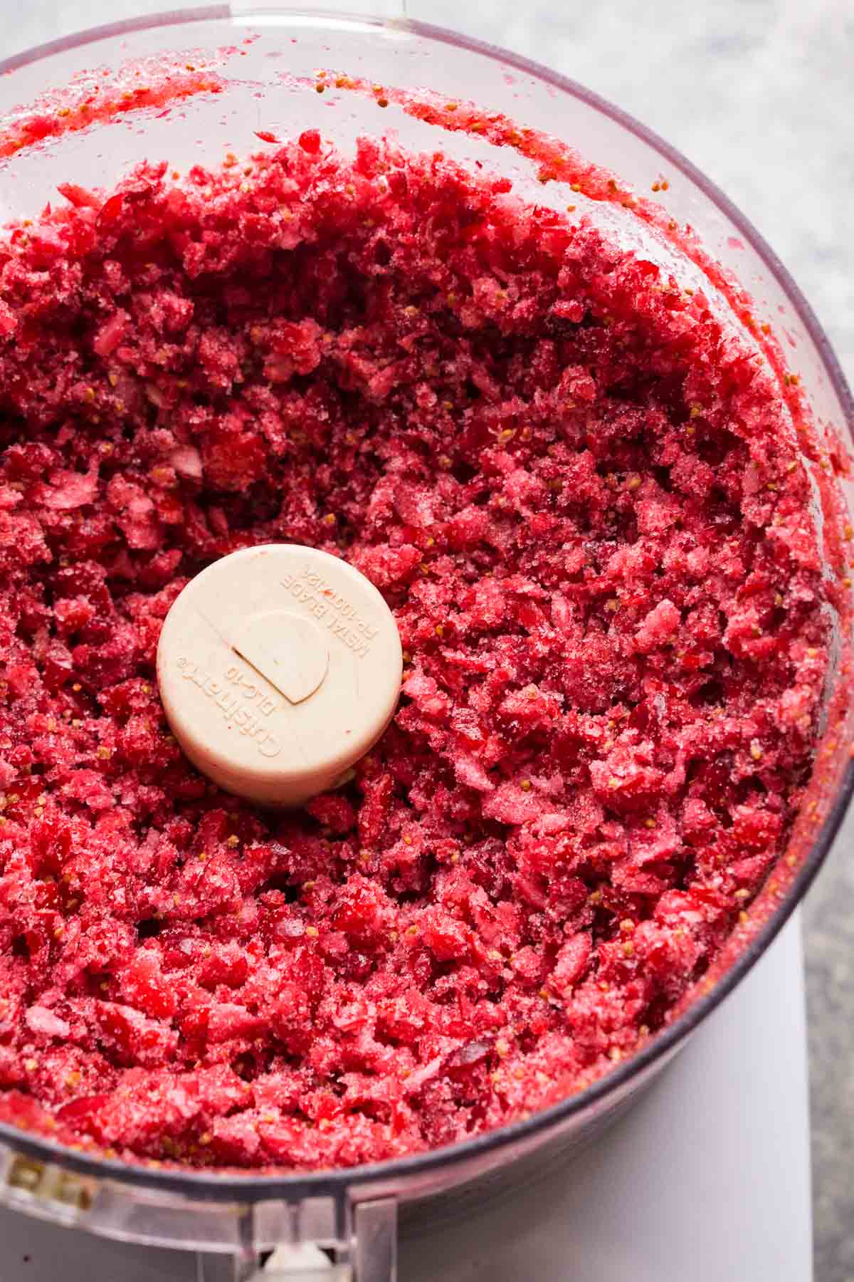 3 ingredient cranberry relish with pomegranate might just become your new favorite Thanksgiving holiday sauce. It's so easy to blend raw cranberries, fold in sugar and pomegranate, and let it macerate a few days in the refrigerator until it become juicy and so mouthwatering. You'll love how pomegranate cranberry relish tastes when it's served alongside holiday turkey, mashed potatoes, and gravy. finely chopped cranberries in food processor