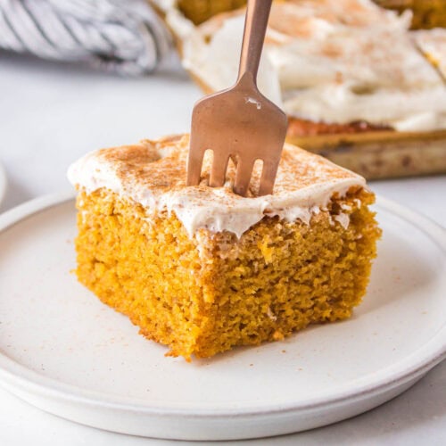 Fork is inserted into pumpkin bar on white plate.