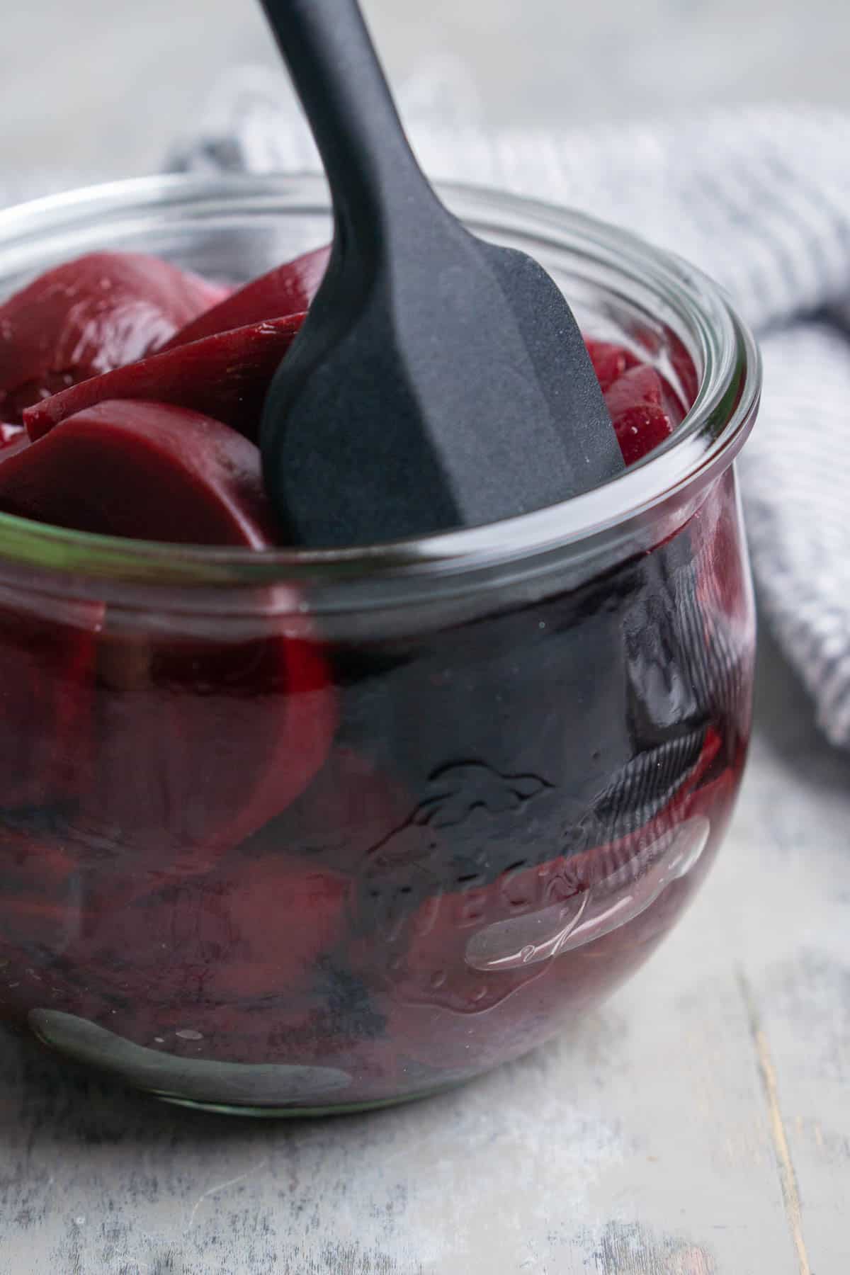 black silicone patula removes air bubbles from pickle beets in glass jar
