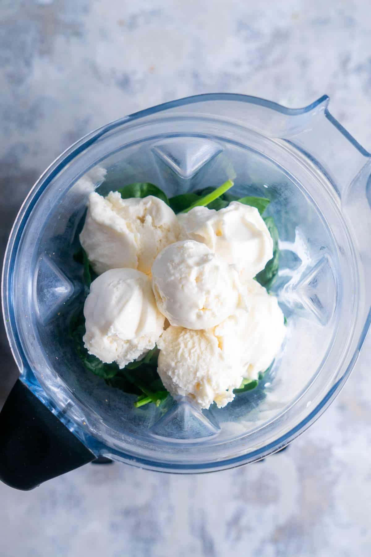 vanilla ice cream and fresh spinach leaves in blender