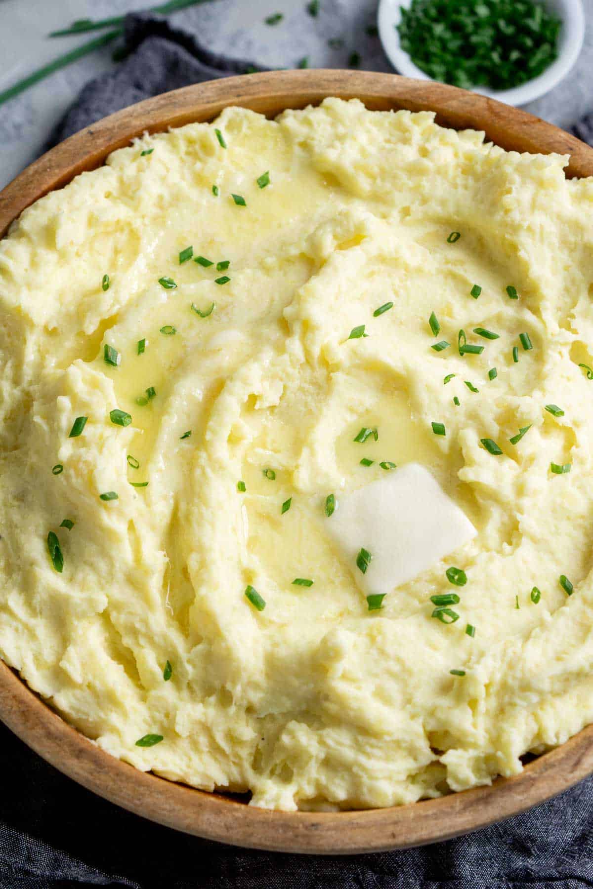 sour cream mashed potatoes with fresh chives in wood serving bowl