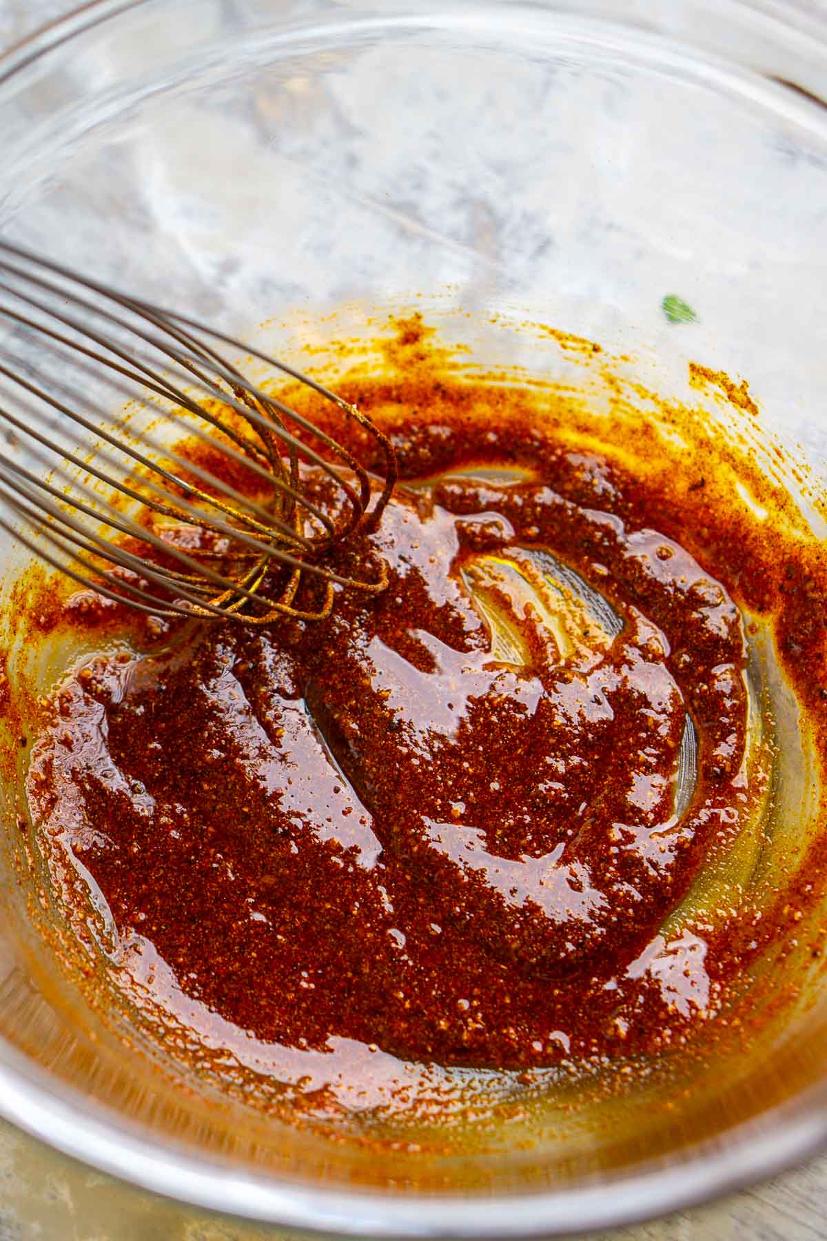 Fajita marinade is whisked in glass mixing bowl.