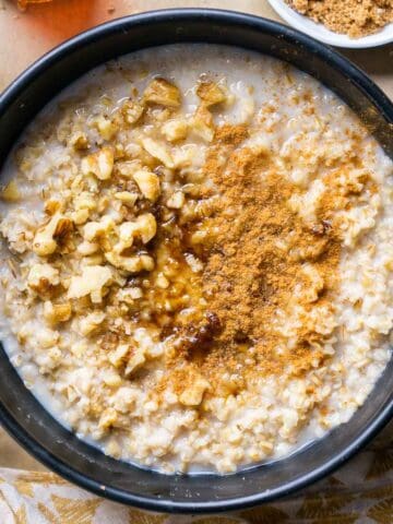steel cut oats with toppings in black bowl