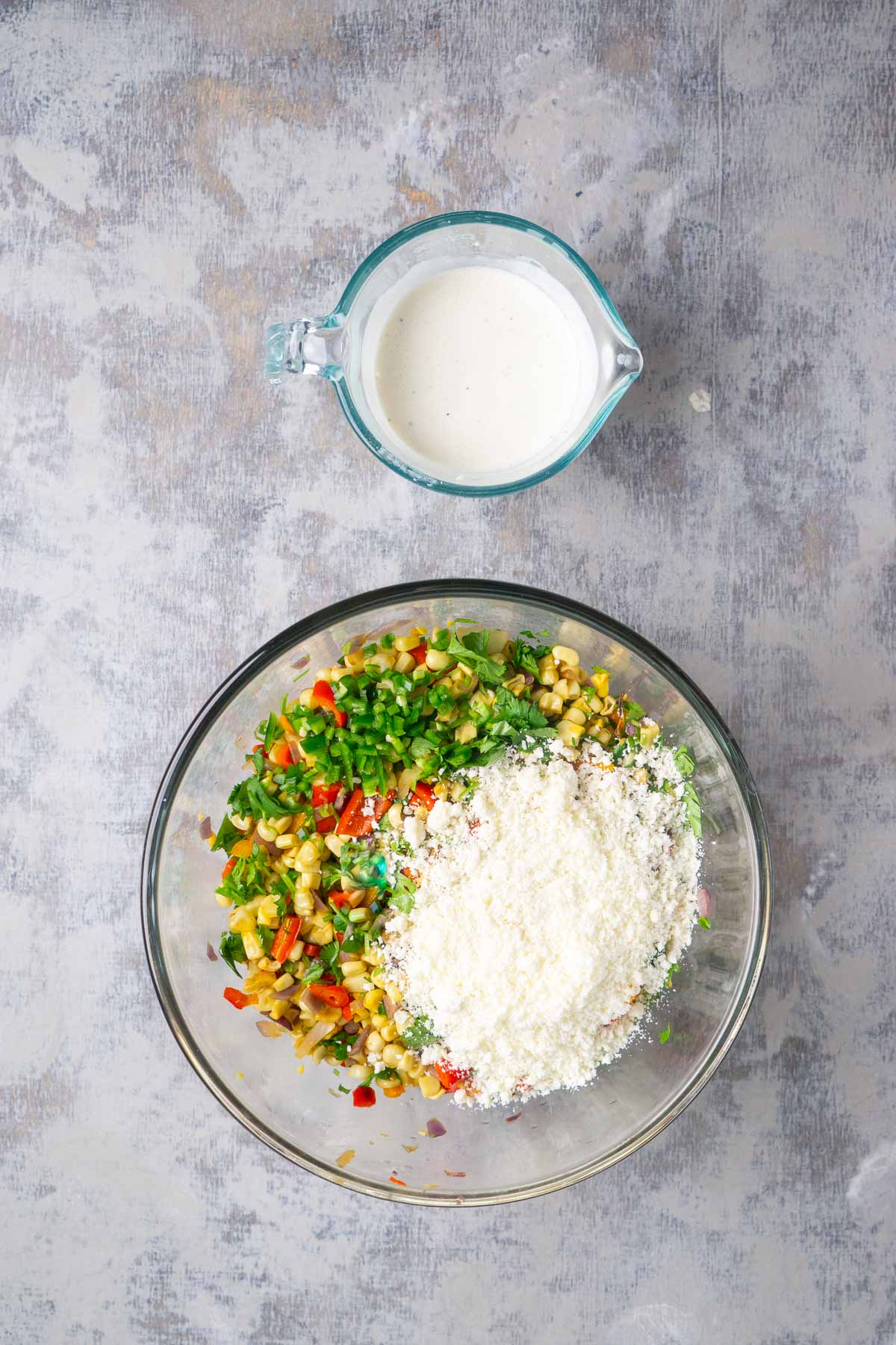 Ingredients for street corn salad in glass mixing bowls.