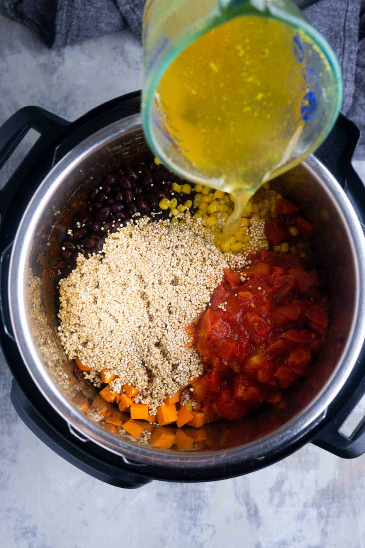 sweet potato black bean chili ingredients are being added to the Instant Pot