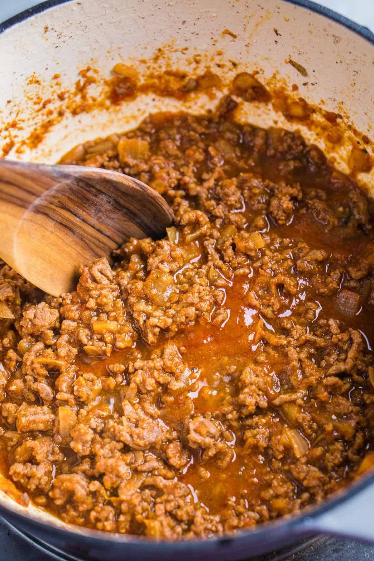 wooden spoon stirs taco meat in skillet