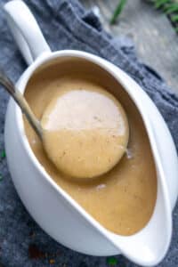 turkey gravy is ladled from white gravy boat