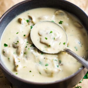 vegan cream of mushroom soup in brown bowl with spoon