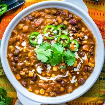 comforting bowl of Instant pot vegetarian chili with beans, cilantro, jalapeno and sour creme garnish