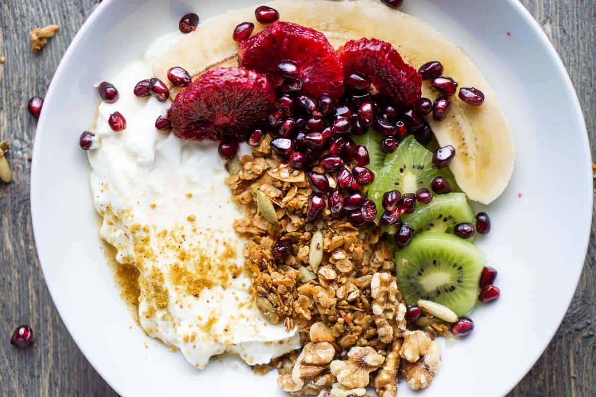 yogurt, granola, and fresh fruit in white bowl